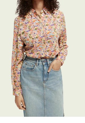 Floral button-up shirt featuring a mix of pink, orange, and green hues; long sleeves; soft fabric; paired with a light denim skirt.