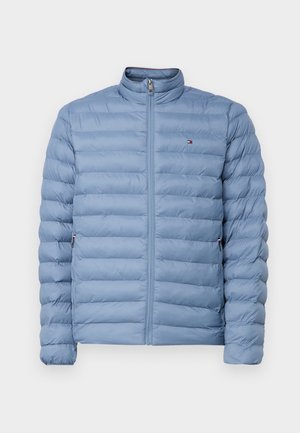 Világoskék steppelt dzseki álló gallérral, steppelt textúrával, elöl cipzárral és oldalzsebekkel. A mellkason egy apró logó található.