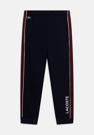 Merihenkiset sweats-housut maroon-värisillä sivuraidoilla. Varustettu valkoisella logolla, joustavalla vyötäröllä ja ribbattuilla hihansuilla. Pehmeää puuvillamateriaalia.
