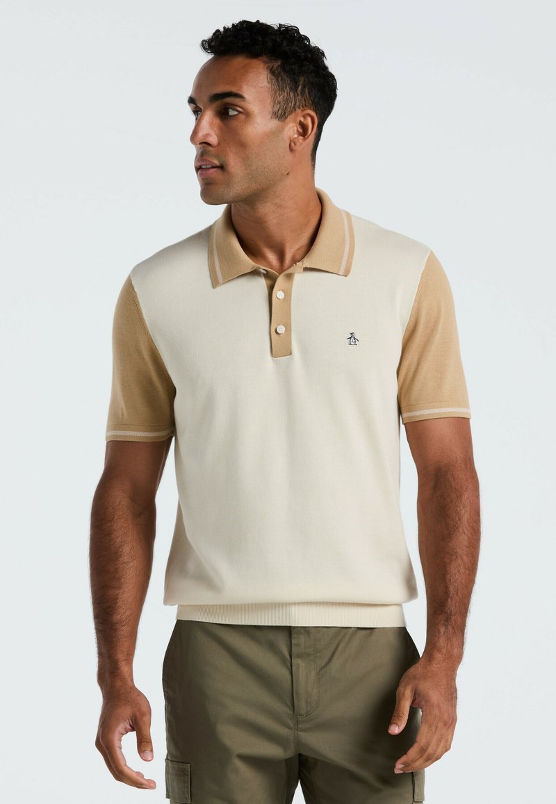 Beige und cremefarbener Kurzarm-Polo-Shirt mit Kragen, drei Knöpfen und kleinem Logo. Weicher Stoff mit kontrastierenden Ärmelfarben.