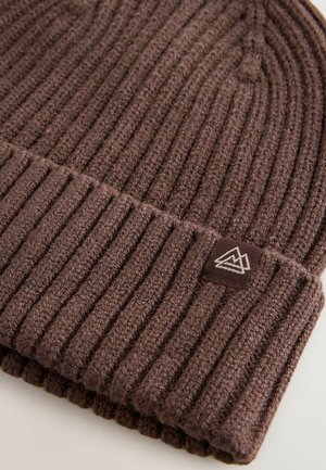 Braune Strickmütze mit geripptem Design und umgeschlagenem Bündchen. Verfügt über ein kleines gewebtes Etikett mit einem Bergdesign. Hergestellt aus warmem Material.