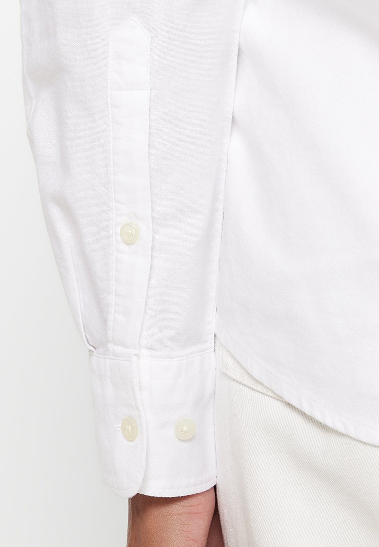 Weißes Baumwollhemd mit einem Knopfmanschette, aus strukturiertem Stoff und kleinen, durchsichtigen Knöpfen.