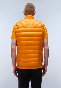 Padded orange vest with a high collar, featuring horizontal stitching and a smooth texture. Worn over a matching orange shirt.