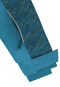 Ärmel einer türkisfarbenen Jacke, das mit einem gemusterten Stoff in Blau und Gelb mit Punkten und Zickzacklinien versehen ist. Glatte Textur und kontrastierendes Bündchen.