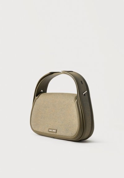 Petit sac à main vert olive avec poignée courbée, panneau avant en tissu et étiquette de marque en métal sur le devant, présenté sur fond blanc.