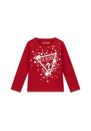 Chemise rouge à manches longues pour enfant avec un triangle blanc du logo Guess et un motif d’étoiles dispersées à l’avant.