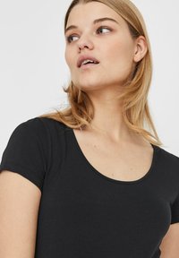 Sort kortærmet T-shirt med scoop-halsudskæring, lavet af et glat, strækbart stof. Har minimale sømme og en ren silhuet.