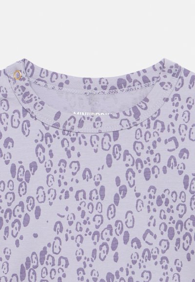 Λιλά κοντομάνικο πουκάμισο με υφή και σχέδιο λιονταριού σε σκούρο μοβ. Στρογγυλή λαιμόκοψη με λεπτομέρεια από κουμπί snap.