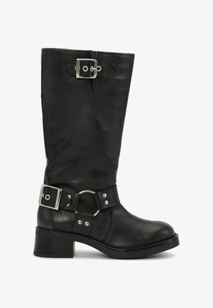 Zwarte leren laars tot halverwege de kuit met twee zilveren gespen, één nabij de bovenkant en één rond de enkel, met metalen ring en studs, lage blokhak.