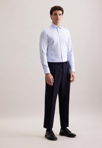 Lichtblauw gestreept overhemd met lange mouwen, gecombineerd met donker marineblauwe broek en zwarte veterschoenen. Schoon, op maat gemaakte pasvorm.