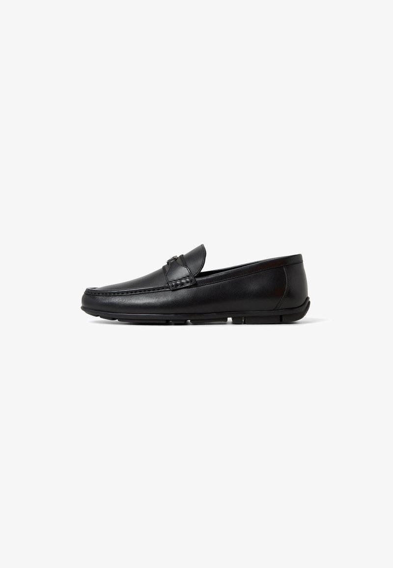 Black leather loafers with a low profile, rounded toe, and stitched detailing on the upper. Flexible rubber sole for comfort and grip.