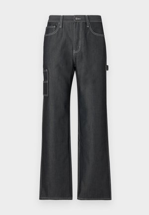 Pantalons cargo en denim foncé avec une coupe large, des coutures blanches contrastées, des poches latérales et une poche à rabat sur la jambe gauche.