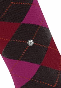 Calza a rombi con sfumature di rosa, rosso e nero, con cuciture arancioni a contrasto e un accento a forma di logo circolare.