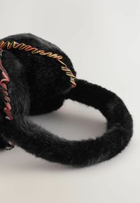 Sort faux fur pandebånd med multikolorede og lyserøde frynse-bånd detaljer på en ensfarvet lys baggrund.
