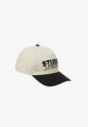 Baseballcap i cremefarvet stof med en sort skygge. Har broderet tekst i sort, "STUDIO Originals," på forsiden.
