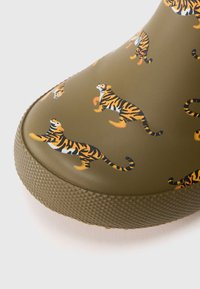 Stivale da pioggia in gomma oliva con una stampa ripetuta di tigri in arancione e nero. Suola testurizzata con punta arrotondata e finitura liscia.