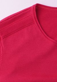 Pull rouge ajusté avec texture en tricot, encolure ronde et coutures d'épaule avec broderies décoratives. Pas de motifs ni de quincaillerie visibles.