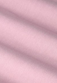 Lichtroze stof met een glad, textuurvlak, met subtiele ribbeling, gerangschikt in zachte plooien.