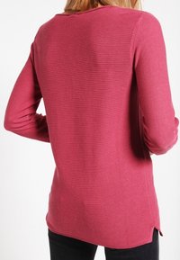 Langärmeliges, geripptes Sweatshirt in Pink mit rundem Ausschnitt und seitlichen Schlitzen. Hergestellt aus strukturiertem Strickstoff für zusätzlichen Komfort und Stil.