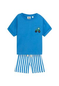 Blå bomulds t-shirt med et grønt traktor design på lommen, parret med hvid- og blåstribede shorts. Simpel pullover stil.