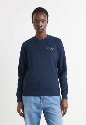 Felpa blu navy in morbido tessuto, con colletto a girocollo e polsini a coste. Il testo ricamato sul petto aggiunge un dettaglio sottile.