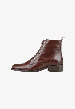 Bottine en cuir marron à finition lisse, bout arrondi, laçage à l'avant, œillets dorés et petit talon bloc.