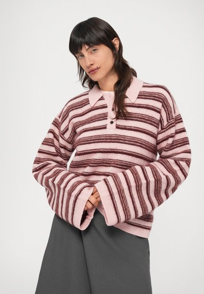 Ροζ και μαρόν ριγωτό πουλόβερ με γιακά, τρία κουμπιά και φαρδιά μανίκια. Μαλακή υφή και άνετη εφαρμογή. Γκρι παντελόνι.