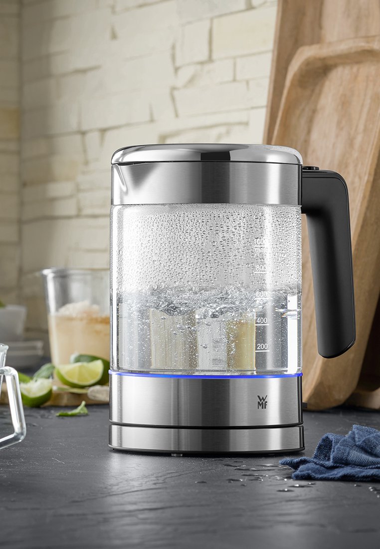 Bouilloire électrique avec une base en acier inoxydable, un réservoir d'eau transparent, des repères de mesure, une poignée noire et un éclairage bleu pendant l'ébullition.