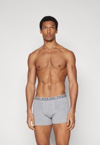 Caleçons en coton gris avec une ceinture élastique bleu marine portant le texte "PIER ONE" en couleurs alternées bleu et blanc.