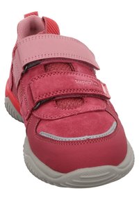 Rosa Kindersneaker mit zwei Klettverschlüssen, Obermaterial aus Wildleder und Mesh, rotem Ziehband und grauer, strukturiertem Gummisohle.