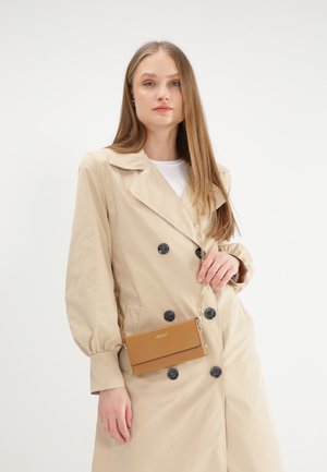 Tan faux leren schoudertas met een gouden kettingriem, voorzien van een magnetische drukknoopsluiting en een reliëflogo aan de voorkant.