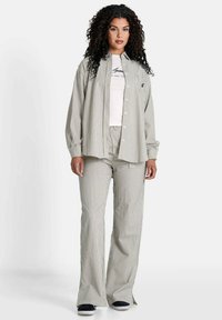 Gestreept zacht stoffen outfit met een knoopsluiting shirt en relaxed-fit broek in lichtgrijs en wit. Inclusief een t-shirt met ronde hals eronder.