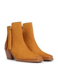 Tan suede nilkkurit, joissa on terävä kärki ja pino korko, sivu vetoketju ja koristeelliset tupsut kannassa.