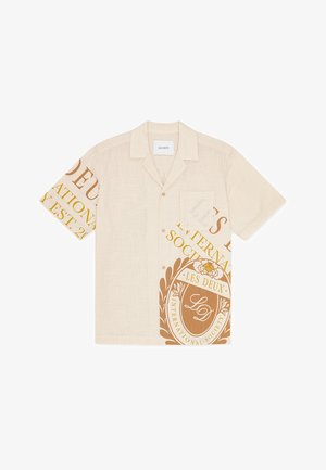 Béžová košeľa s krátkym rukávom, zdobená veľkým hnedým grafickým dizajnom a logom na jednej strane, s jedným náprsným vreckom na ľavej strane.