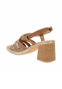 Sandali con tacco tan in materiale sintetico, con design a fascia intrecciata. Tacco spesso e texture, con una leggera lucentezza. Cinturino alla caviglia regolabile.