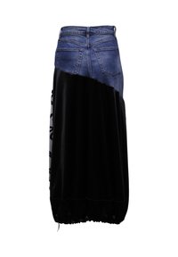 Falda de mezclilla con una sección inferior de terciopelo negro, con un dobladillo fruncido y un diseño ligeramente asimétrico. Bolsillos traseros visibles.