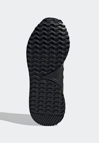 Svart gummisula för sneakers med texturerade spår för grepp, med adidas-logotypen i mitten och ett förstärkt hälområde.