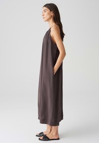 Lässiges, ärmelloses Kleid aus dunkelgrauem Stoff, mit gerafftem Ausschnitt, seitlichen Taschen und gerader Silhouette.