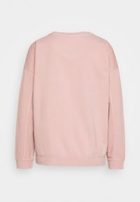 Effen lichtroze sweatshirt met lange mouwen, weergegeven van achteren, met ribgebreide manchetten en zoom op een witte achtergrond.