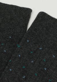 Chaussettes gris foncé en matériau doux, avec une texture côtelée et de petites speckles turquoise et bleues tout au long.