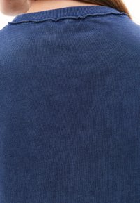 Mørkeblå bomulds sweater med en tekstureret overflade. Har en ribbet halsudskæring og diskret syning langs kraven.