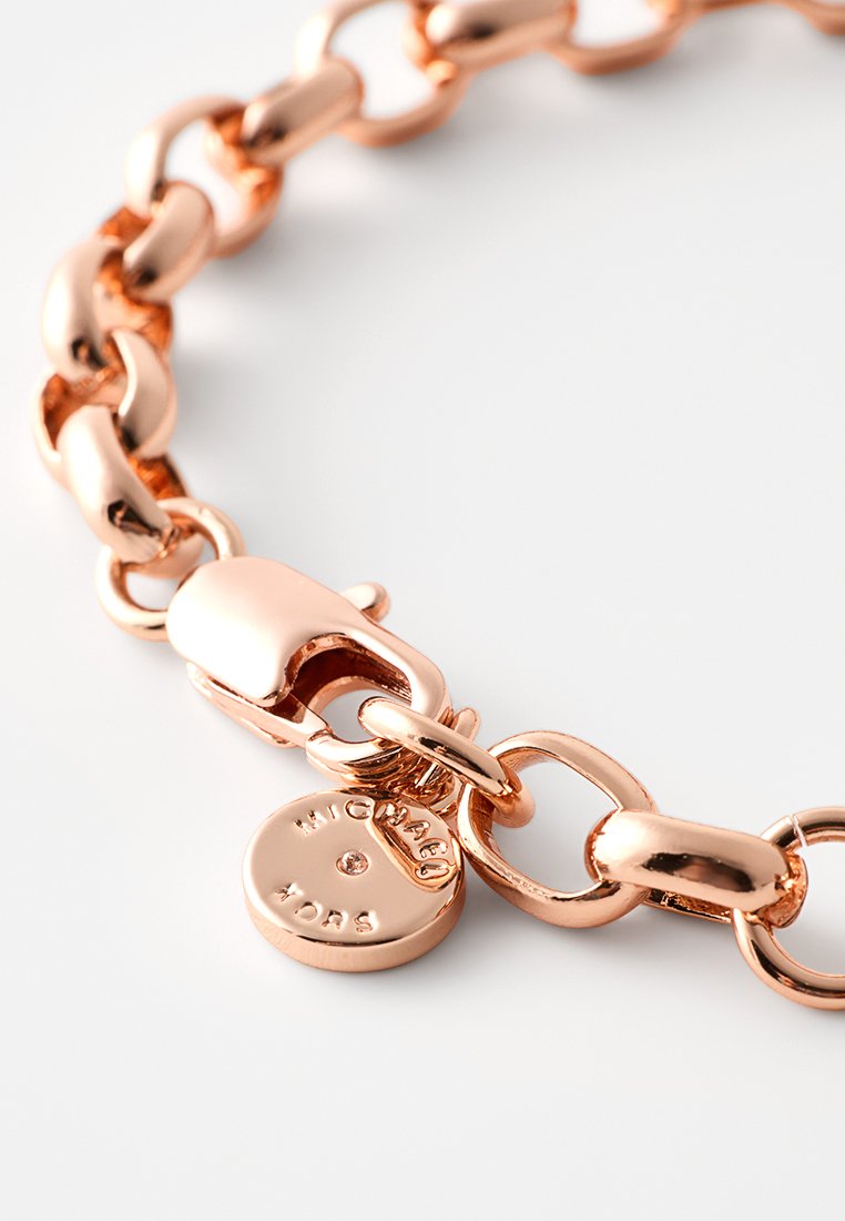 Metallarmband aus poliertem Roségold, mit ineinandergreifenden Gliedern, einem Verschluss und einem Logoschild mit eingraviertem Text und einem kleinen Akzent.