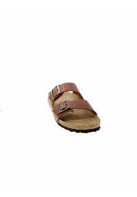 Bruine leren sandalen met twee verstelbare banden en zilveren gespen, voorzien van een kurken voetbed en een gestructureerde zwarte rubberen buitenzool.