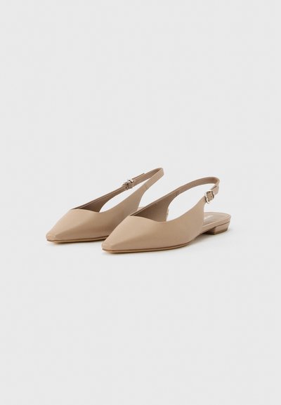 Μπεζ μυτερές slingback μπαλαρίνες με ρυθμιζόμενα λουράκια με αγκράφα και χαμηλές τακούνια σε απλό φωτεινό φόντο.