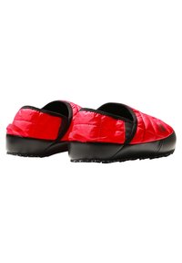 Scarpe slip-on rosse trapuntate con suola in gomma nera, caratterizzate da un profilo basso e sottili accenti neri. Superficie testurizzata con linguetta posteriore.