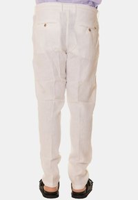 Pantaloni in lino bianchi con una vestibilità dritta, dotati di due tasche posteriori e una trama sottile. Design casual abbinato a calzature scure.