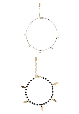 Două brățări delicate din lanț de aur; una cu mărgele negre mici și talismane aurii care atârnă, cealaltă cu mărgele negre alternative și sfere mici din aur.