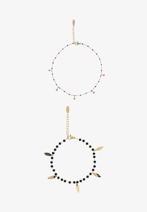 Două brățări delicate din lanț de aur; una cu mărgele negre mici și talismane aurii care atârnă, cealaltă cu mărgele negre alternative și sfere mici din aur.