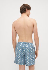 Zili peldbikses ar atkārtotu apaļu formu un zvaigžņu rakstu. Elastīgs jostasvads ar kabatas detaļu aizmugurē.