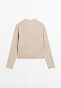 Beige långärmad tröja med en avslappnad passform, ribbade muddkanter och halsringning, tillverkad av mjukt stickat tyg, med en enkel och ren design.